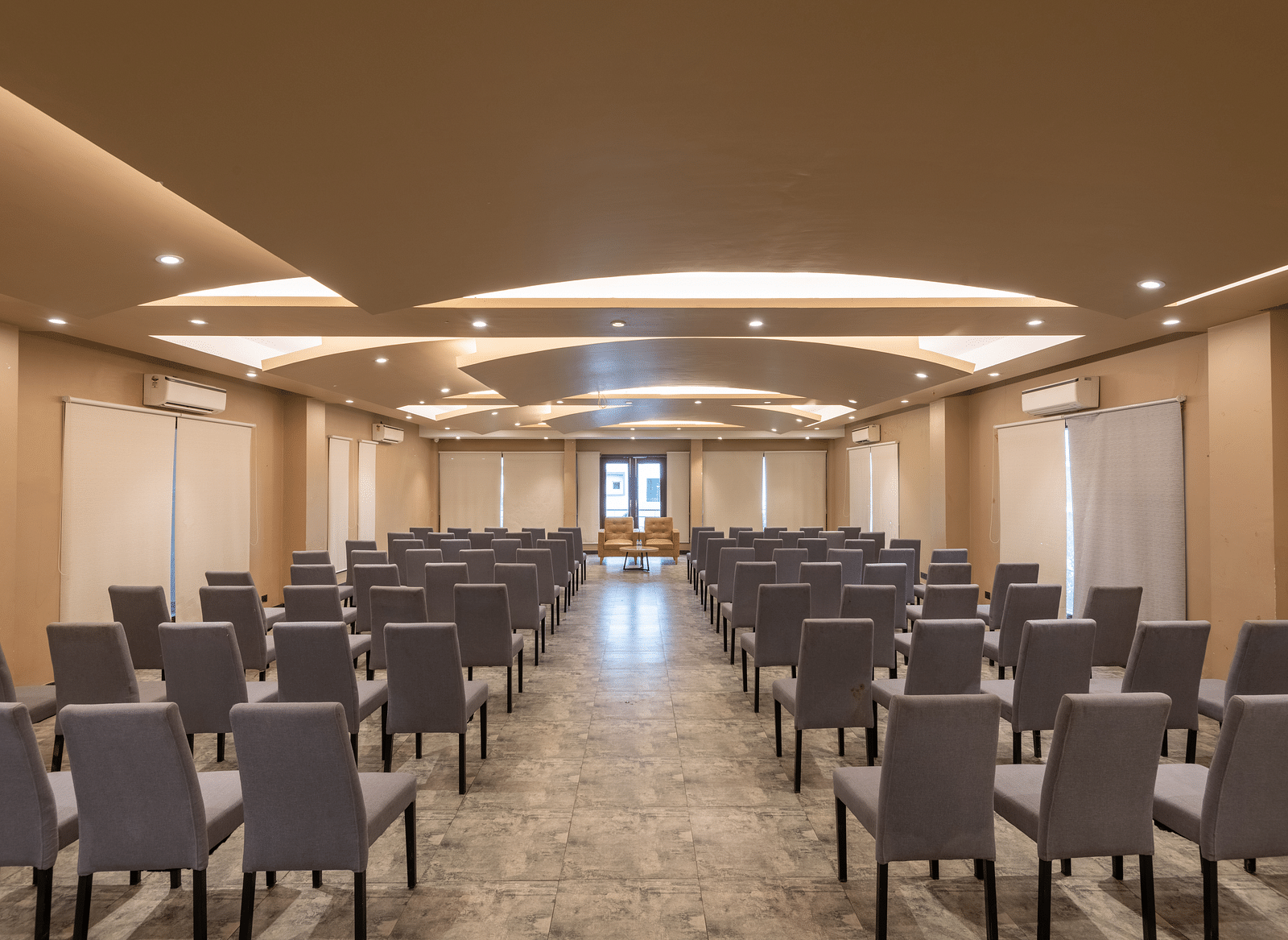 View from the back of the banquet hall at DLS Forest Vines Resort, with chairs neatly arranged on both sides.